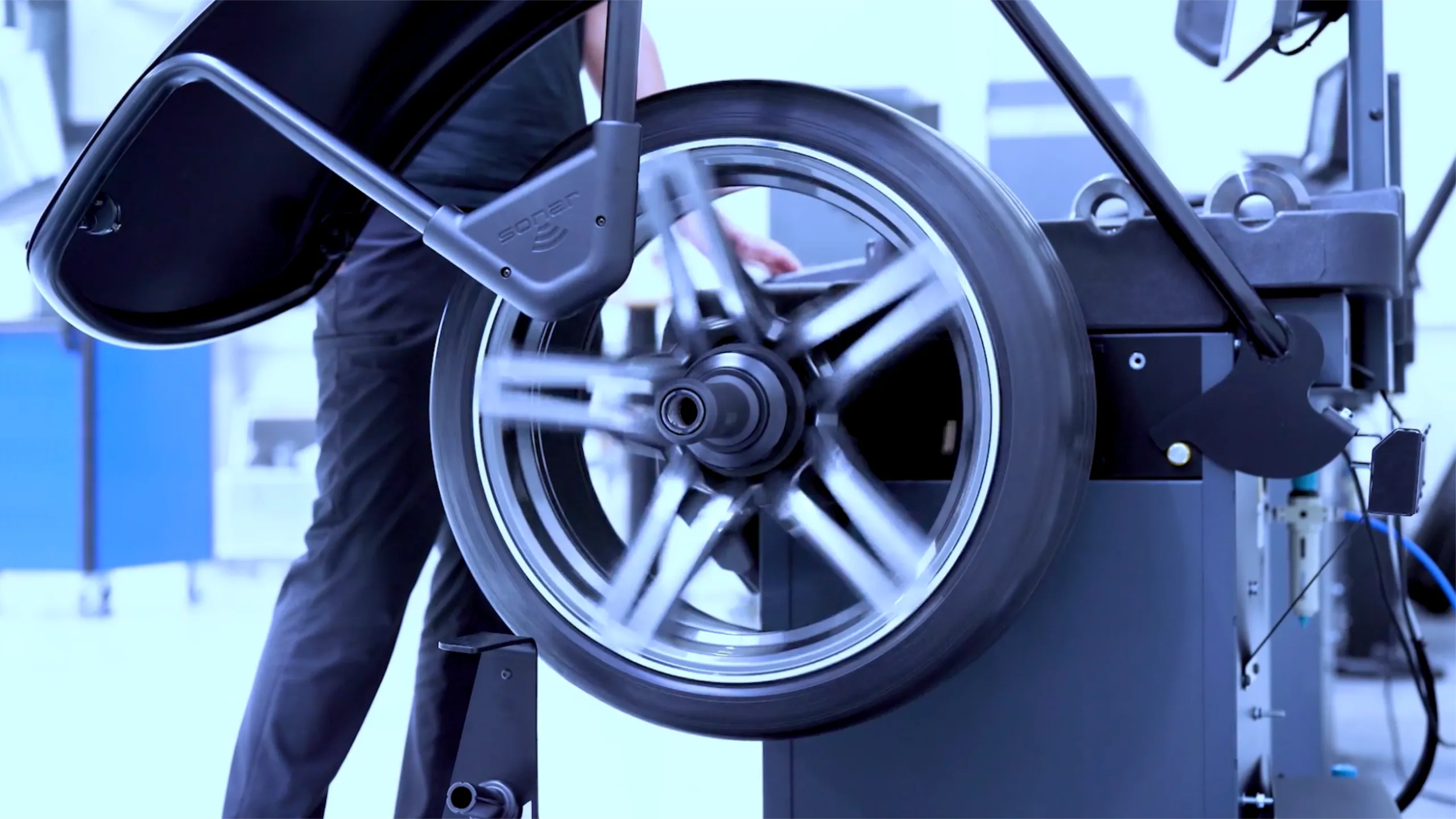 Detailaufnahme eines rotierenden Autoreifens auf einer Werkstattmaschine zur Darstellung von Präzision und Technik