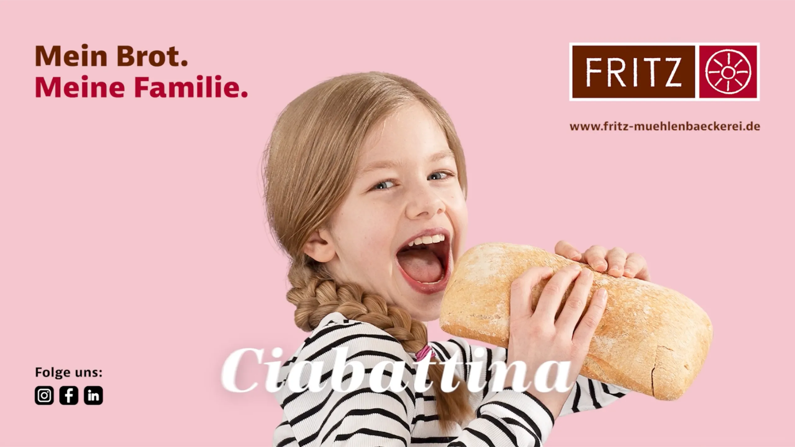 Kind mit Zöpfen beißt spielerisch in ein Brot vor rosa Hintergrund mit Kampagnenclaim der Fritz Mühlenbäckerei